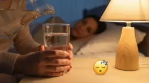 Una persona versa acqua in un bicchiere accanto a un letto con una lampada accesa
